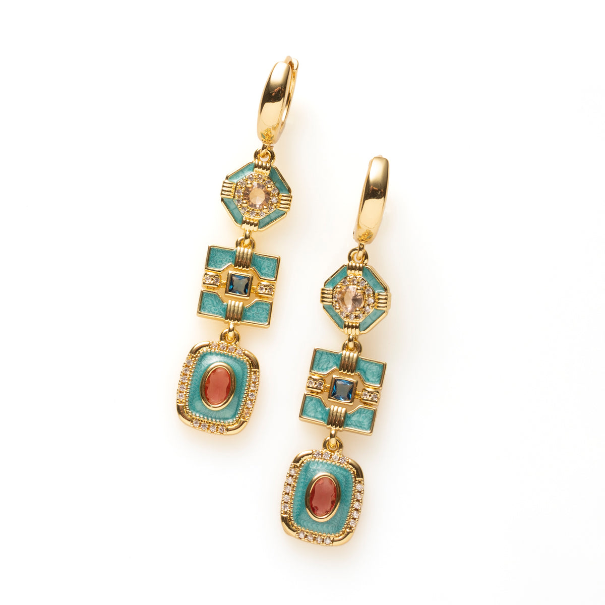 Riviera Deco geeft art deco een eigentijdse twist. Drie geometrische vormen in turquoise emaille hangen sierlijk onder elkaar, elk met een eigen kleuraccent: champagne, diepblauw en roze/rood. Fonkelende zirkonia en warm goud maken het ontwerp rijk en verfijnd, en de lange, verticale lijn geeft het stoerheid.

Deze oorbellen zijn voor de vrouw die iets anders wil dan de standaard gouden oorring: kleur en klasse, zonder dat het te veel wordt. Ze komen het mooist uit bij wit, zwart of denim.