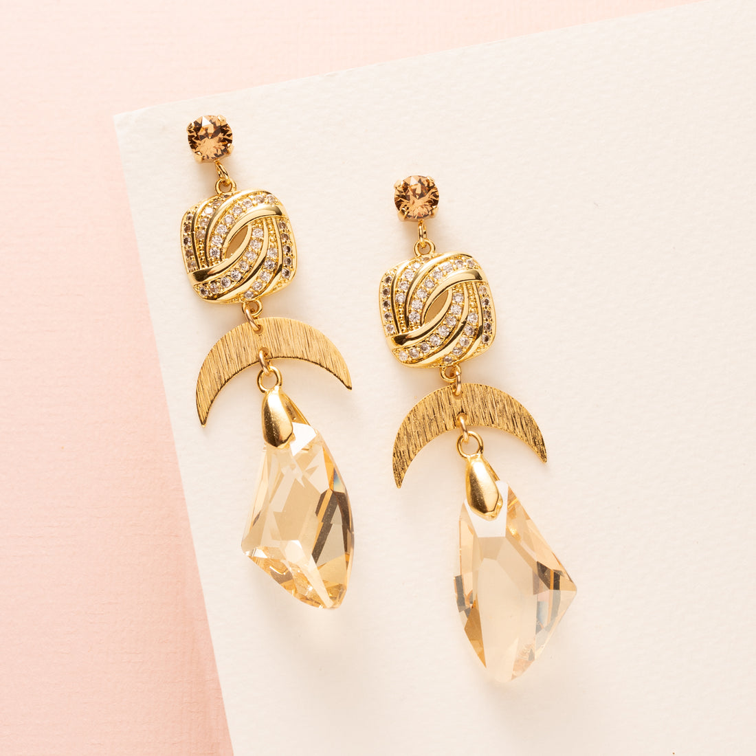 Golden Radiance – opvallende, feestelijke oorbellen die luxe en warmte perfect combineren. De Swarovski oorstekers zorgen voor een sprankelende basis, terwijl de lichtbruine kristalglas druppels een elegante, gouden gloed creëren bij elke beweging.

De rijke goudtinten en het uitgesproken design maken Golden Radiance ideaal voor de feestdagen: chic, glam en onweerstaanbaar opvallend. Perfect voor een diner, feestje of elke gelegenheid waarop je schitterend voor de dag wilt komen.