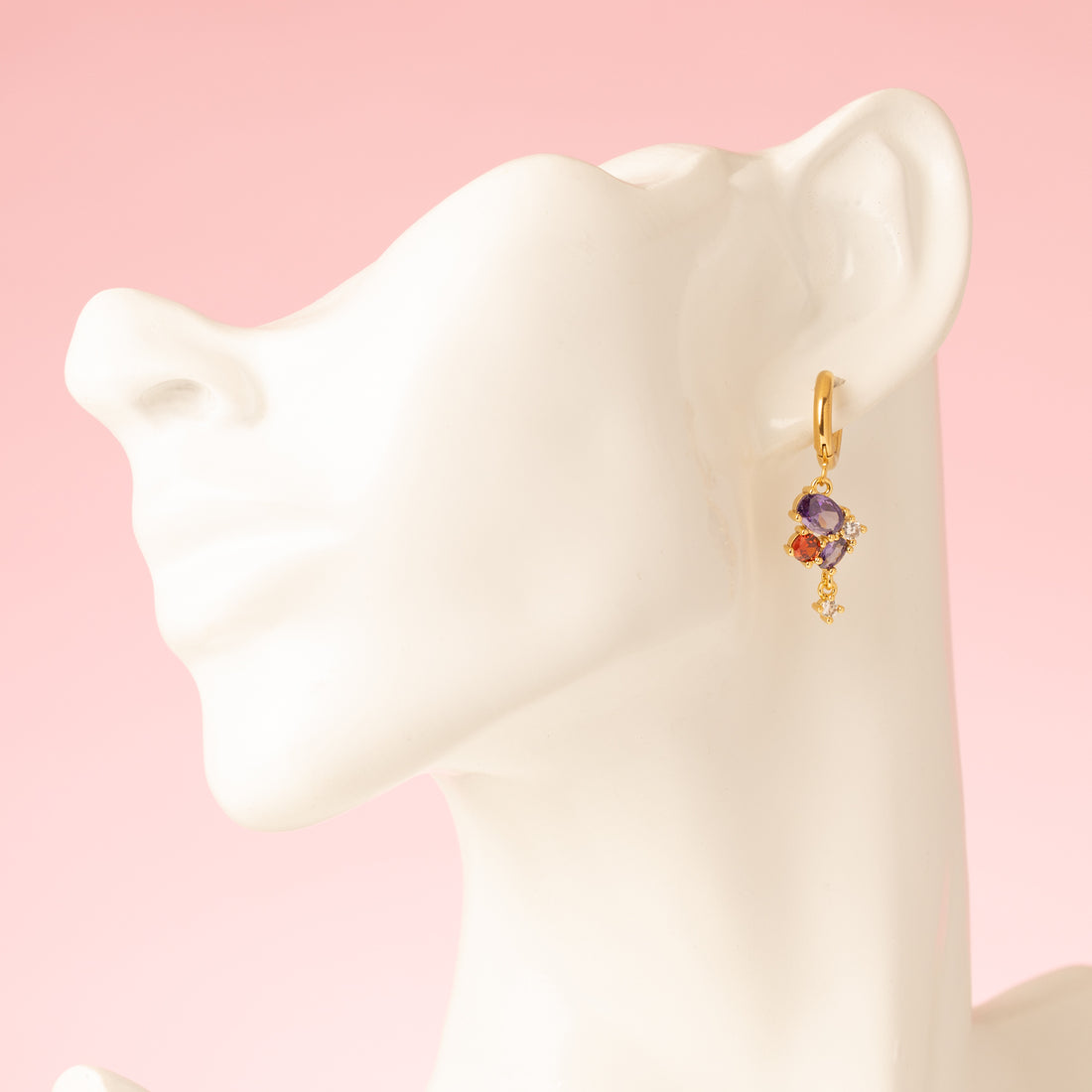Crimson Glow is klein van formaat maar groots in uitstraling. Deze elegante 18 kt gold plated oorringen zijn afgewerkt met een opvallende bedel vol schitterende zirkonia in paars en rood. Een subtiele eyecatcher voor elke dag of een chique avond uit.