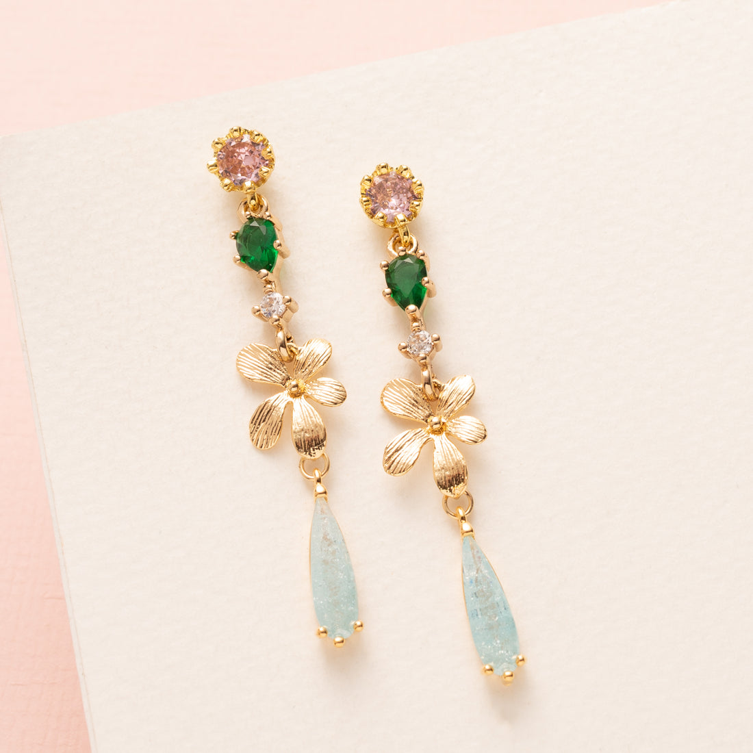 Breng een verfijnde herfstachtige elegantie in je look met de Whispering Grove oorbellen. Lichtroze zirkonia oorstekers vormen een zacht begin, gecombineerd met een frisgroen zirkonia tussenstuk daar onder een gouden bloem. Subtiele lichtblauwe zirkonia druppels geven een sprankelend accent en maken deze oorbellen perfect voor het najaar, naar kantoor of een etentje. Elegant, stijlvol en tijdloos en een gedurfde kleurcombinatie.