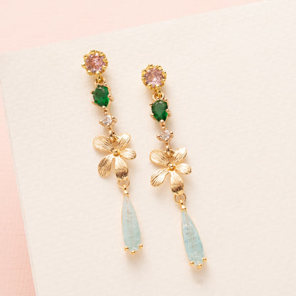 Breng een verfijnde herfstachtige elegantie in je look met de Whispering Grove oorbellen. Lichtroze zirkonia oorstekers vormen een zacht begin, gecombineerd met een frisgroen zirkonia tussenstuk daar onder een gouden bloem. Subtiele lichtblauwe zirkonia druppels geven een sprankelend accent en maken deze oorbellen perfect voor het najaar, naar kantoor of een etentje. Elegant, stijlvol en tijdloos en een gedurfde kleurcombinatie.
