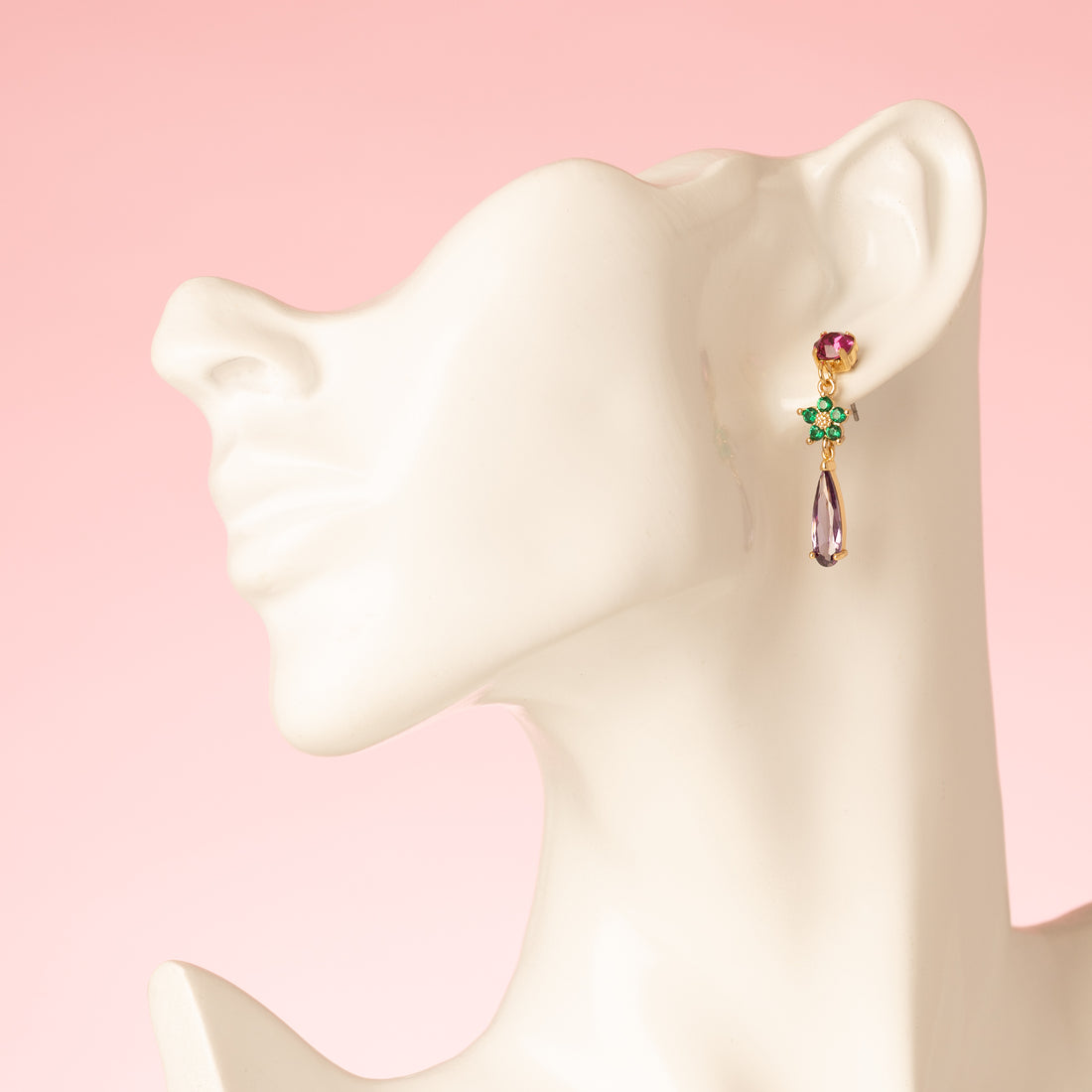 Laat je betoveren door de kleurrijke elegantie van Purple Meadow. Deze fijne statement oorbellen combineren een fuchsia Swarovski oorsteker met een frisgroen kristallen bloemetje en een subtiele paarse druppel van kristalglas. Het resultaat? Een opvallende, maar verfijnde look die je zowel overdag als ’s avonds laat stralen. Perfect voor het najaar, maar tijdloos genoeg om het hele jaar door te dragen. Draag ze naar kantoor of maak je outfit af voor een avondje uit