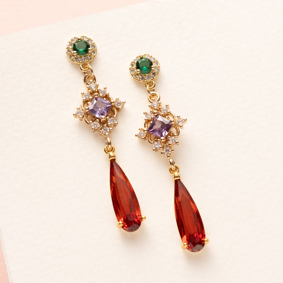 Autumn Glow – Flame geeft een speelse twist aan dezze elegante oorbellen. De groene zirkonia oorsteker, het paarse tussenstuk en de oranje crystal druppel maken dit paar een opvallend maar verfijnd accessoire. Ideaal voor een chique dag- of avondlook in de herfst.