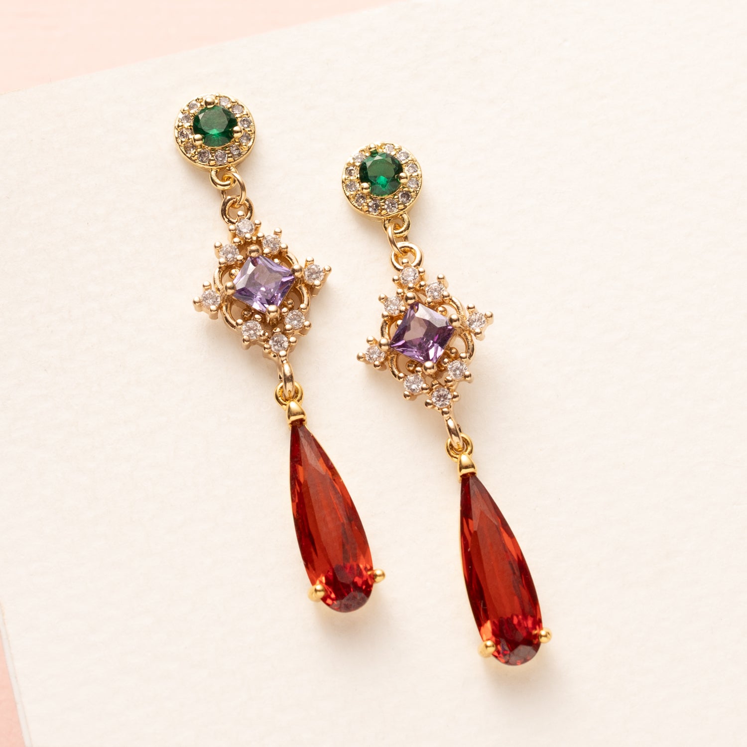 Autumn Glow – Flame geeft een speelse twist aan dezze elegante oorbellen. De groene zirkonia oorsteker, het paarse tussenstuk en de oranje crystal druppel maken dit paar een opvallend maar verfijnd accessoire. Ideaal voor een chique dag- of avondlook in de herfst.