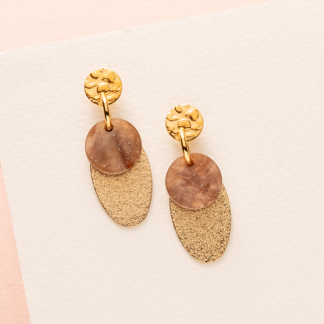 Elegante oorbellen met een warme, bruine resin bedel die elke outfit een tijdloze glow geeft. De verfijnde vorm en de zachte glans van het resin creëren een stijlvolle balans tussen modern en klassiek. Perfect voor kantoor, een etentje of elke dag.

Deze oorbellen voegen een natuurlijke warmte toe aan je look en zijn moeiteloos te combineren met herfst- en wintertinten, maar net zo stralend in het voorjaar. Een elegant accent dat je iedere dag met vertrouwen draagt.