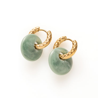 Laat je dag beginnen met een vleugje zachte elegantie. Gentle Green combineert een oorring met reliëf met een ronde Polaris hanger in een frisse erinite-groene tint. Tijdloos, eenvoudig en perfect in balans – een subtiele blikvanger voor elke dag.