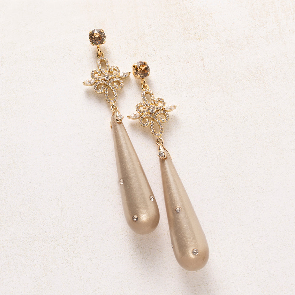 Laat je betoveren door de verfijnde elegantie van Moonlight Grace. Deze elegante oorbellen combineren een warme champagnekleurige Polaris druppel, subtiel bezet met fonkelende Swarovski steentjes en een schitterend tussenstuk vol zirkonia. De oorbel sluit met een Swarovski oorsteker in smoky champagne, die het geheel een warme, luxe glans geeft.

De druppel beweegt sierlijk mee bij elke stap en vangt het licht vanuit elke hoek. Opvallend zonder overdaad, vrouwelijk en tijdloos.

Perfect voor een avondje uit