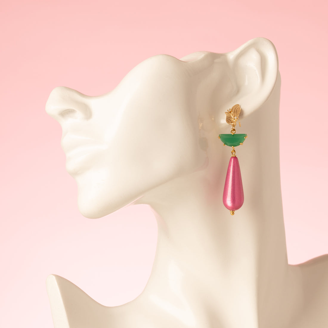 Statement oorbellen met een gouden oorsteker in de vorm van een blaadje, subtiel bezet met zirkonia. Het tussenstuk is een groene half ronde hanger van crystal glas, met daaronder een sprankelende fuchsia polaris druppel. Elegant, opvallend en een echte eyecatcher, maar toch stijlvol genoeg voor op kantoor of een chique casual look.