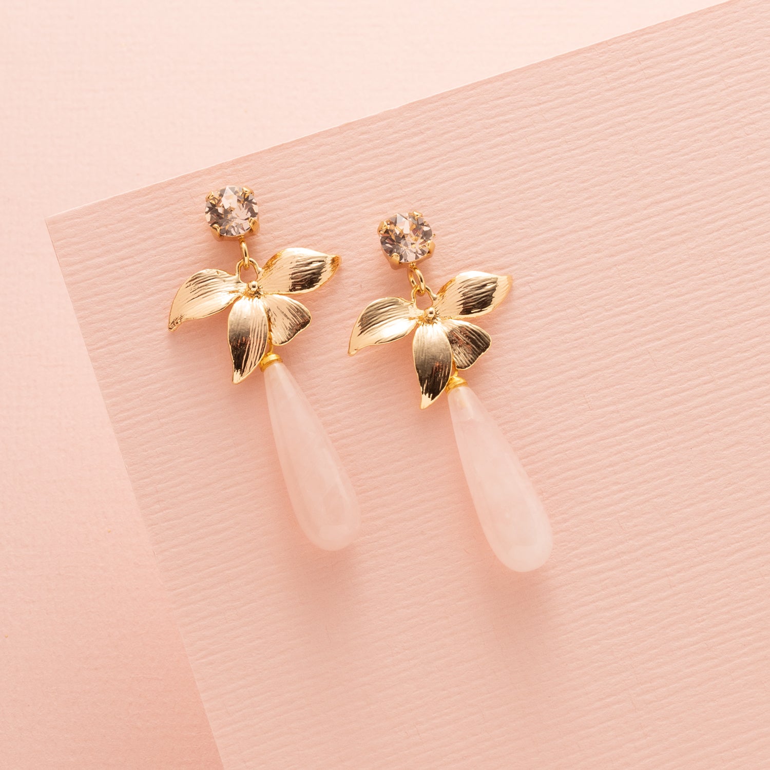 Zachtroze tinten en verfijnde details komen samen in Rose Quartz Bloom – elegante oorbellen met een vrouwelijke en tijdloze uitstraling. De Swarovski steker in de kleur Silk (lichtroze) vangt het licht op een subtiele manier, terwijl de gouden bloem zorgt voor een sierlijke overgang naar de natuurlijke rozenkwarts druppel.