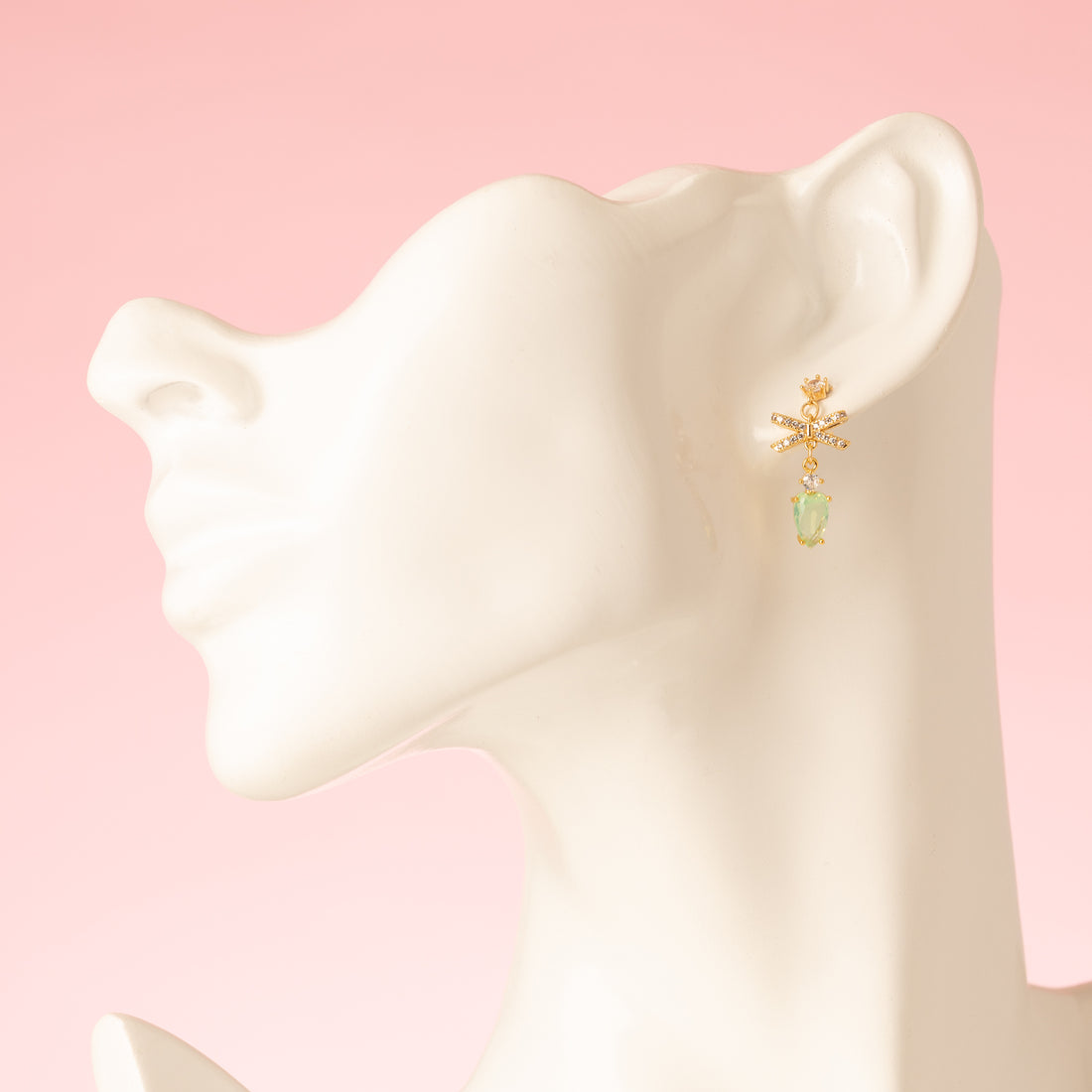 Subtiel en verfijnd: Rosebud Bow combineert kleine zirkonia oorstekers met een zeegroene druppel en een klein zirkonia strikje voor een elegante, speelse touch. Perfect voor dagelijks gebruik of een minimalistisch kleuraccent.