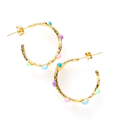Pastel Garden brengt de zachtheid van de natuur naar je sieradencollectie. Deze 18 kt gold plated oorringen zijn vormgegeven als sierlijke takjes, bezet met fijne blaadjes in mintgroen, lichtblauw, lichtroze en lila en donkerblauw. Speels, verfijnd en uniek — perfect voor wie houdt van natuurlijke elegantie met een kleurrijk accent.