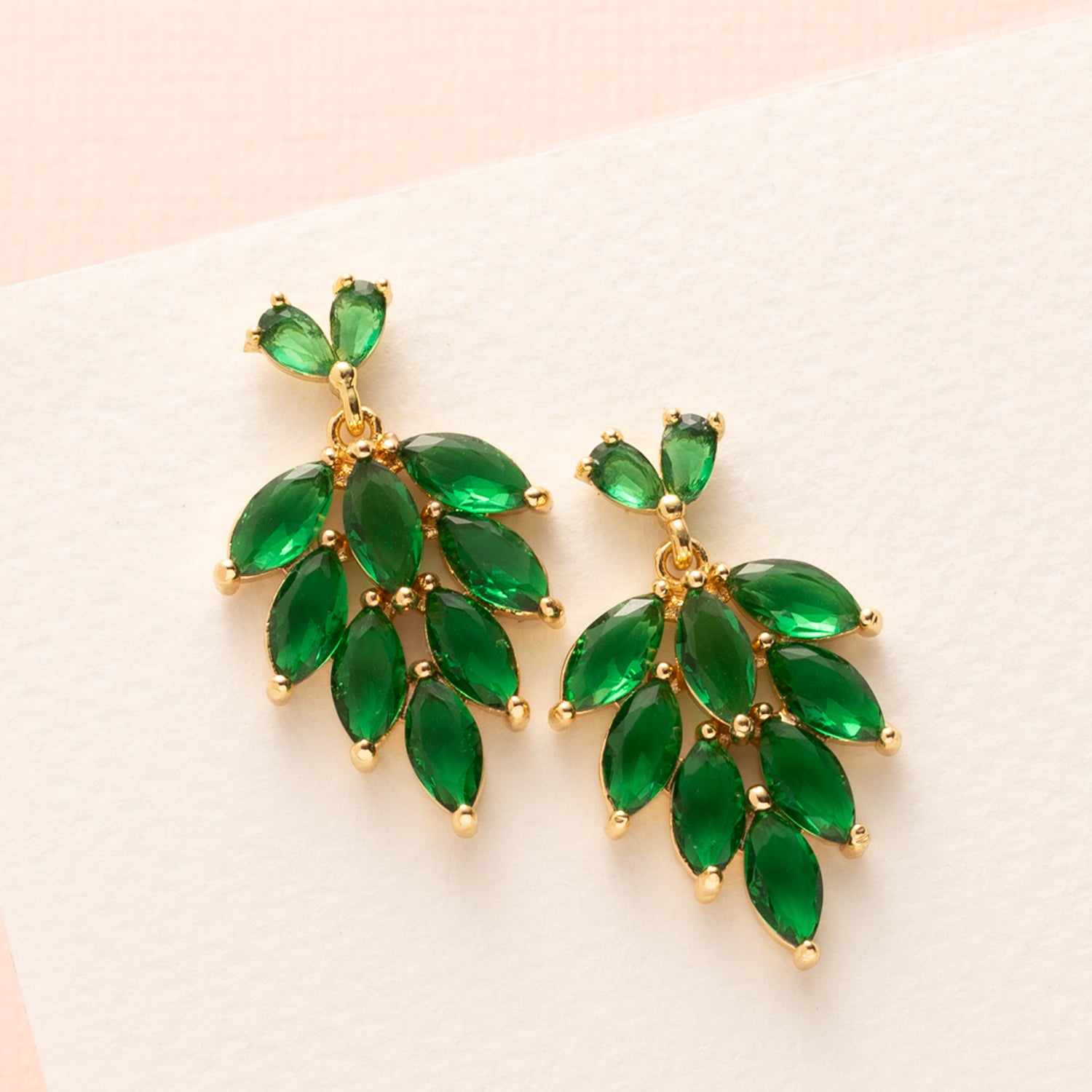 Vier de feestdagen in stijl met deze middelgrote oorbellen die meteen de aandacht trekken. De groene zirkonia blaadjes schitteren subtiel bij elke beweging en geven een elegante, feestelijke uitstraling. De rijke groene tint past perfect bij kerstlooks en voegt een luxe, natuurlijke flair toe. Ideaal voor wie tijdens de feestdagen wil stralen met iets bijzonders.