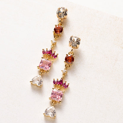 Royal Blush is een kleine verzameling juwelen in één oorbel. Onder een fonkelende Swarovski oorsteker volgen zirkonia steentjes in warm rood, fuchsia en zacht roze. Een kroontje van marquise-geslepen steentjes rust boven een vierkante roze steen, en een helder hartje vormt het slotstuk.

De kleuren lopen van diep naar licht, en de gouden zetting houdt alles verfijnd. Deze oorbellen staan mooi bij een eenvoudige outfit, maar net zo goed bij een feestelijke look.