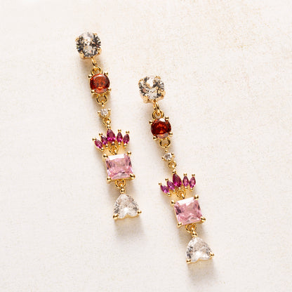 Royal Blush is een kleine verzameling juwelen in één oorbel. Onder een fonkelende Swarovski oorsteker volgen zirkonia steentjes in warm rood, fuchsia en zacht roze. Een kroontje van marquise-geslepen steentjes rust boven een vierkante roze steen, en een helder hartje vormt het slotstuk.

De kleuren lopen van diep naar licht, en de gouden zetting houdt alles verfijnd. Deze oorbellen staan mooi bij een eenvoudige outfit, maar net zo goed bij een feestelijke look.