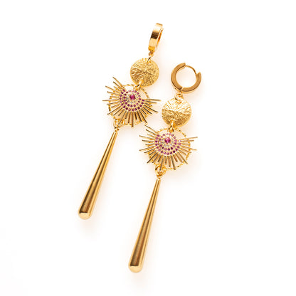 Fuchsia Flare is groot, opvallend en onmiskenbaar aanwezig. Brede gouden zonnestralen rond een kern van fuchsia zirkonia trekken meteen de aandacht en de lange, massieve hanger geeft het ontwerp lengte en gewicht. Deze oorbellen zijn de blikvanger van je outfit.

Geschikt voor overdag of als eyecatcher voor een avondje uit