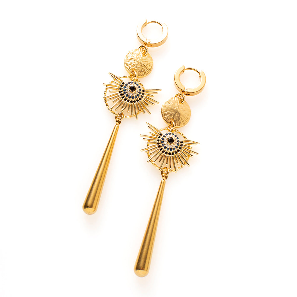 Midnight Sun combineert warm goud met zwarte zirkonia, en dat maakt deze oorbellen stoer en krachtig. De uitwaaierende stralen en de lange gouden hanger zorgen voor een groot, uitgesproken silhouet dat van een afstand al opvalt.

Bij een zwarte coltrui zijn ze stoer, bij een avondjurk dramatisch. Ze maken in beide gevallen het verschil.