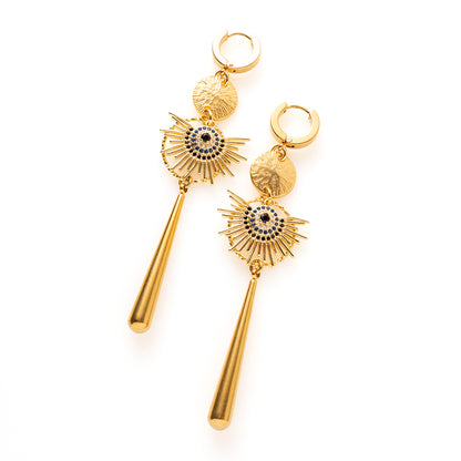 Midnight Sun combineert warm goud met zwarte zirkonia, en dat maakt deze oorbellen stoer en krachtig. De uitwaaierende stralen en de lange gouden hanger zorgen voor een groot, uitgesproken silhouet dat van een afstand al opvalt.

Bij een zwarte coltrui zijn ze stoer, bij een avondjurk dramatisch. Ze maken in beide gevallen het verschil.