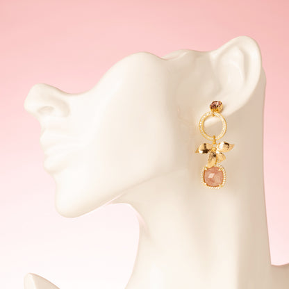 Voeg een verfijnd en vrouwelijk accent toe met de Berry Blush asymmetrische oorbellen. Deze elegante oorbellen combineren een fonkelende Swarovski oorsteker met een gouden bloem, sprankelende zirkonia cirkels en een unieke aardbeienkwarts edelsteen. De steen heeft een warme roze/rode tint die subtiel schittert bij elke beweging. Het asymmetrische ontwerp geeft een speelse twist aan deze chique oorbellen – perfect voor een diner, een bijzondere gelegenheid of als stijlvolle finishing touch voor je dagelijkse