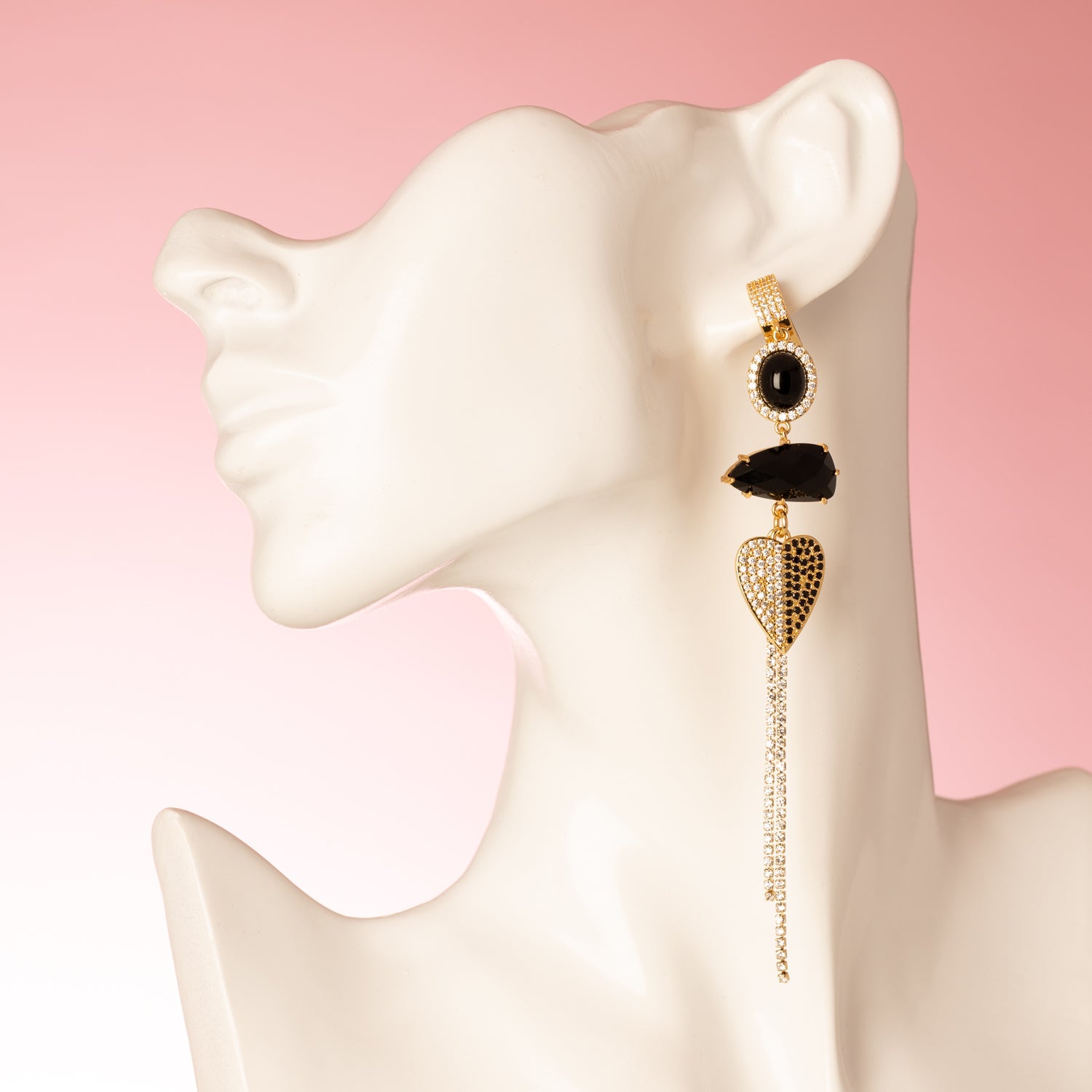 Deze handgemaakte asymmetrische statement oorbellen combineren diepe zwarte zirkonia, fonkelend kristalglas en twee verfijnde accenten: een zirkonia hart en een sierlijke vogel. Het spel tussen licht en donker, lengte en asymmetrie, maakt dit ontwerp heerlijk opvallend zonder zijn elegantie te verliezen.

Voor de vrouw die haar eigen pad volgt, die graag gezien mag worden en zich met trots onderscheidt — met een vleugje fluweelzachte luxe in elke beweging.