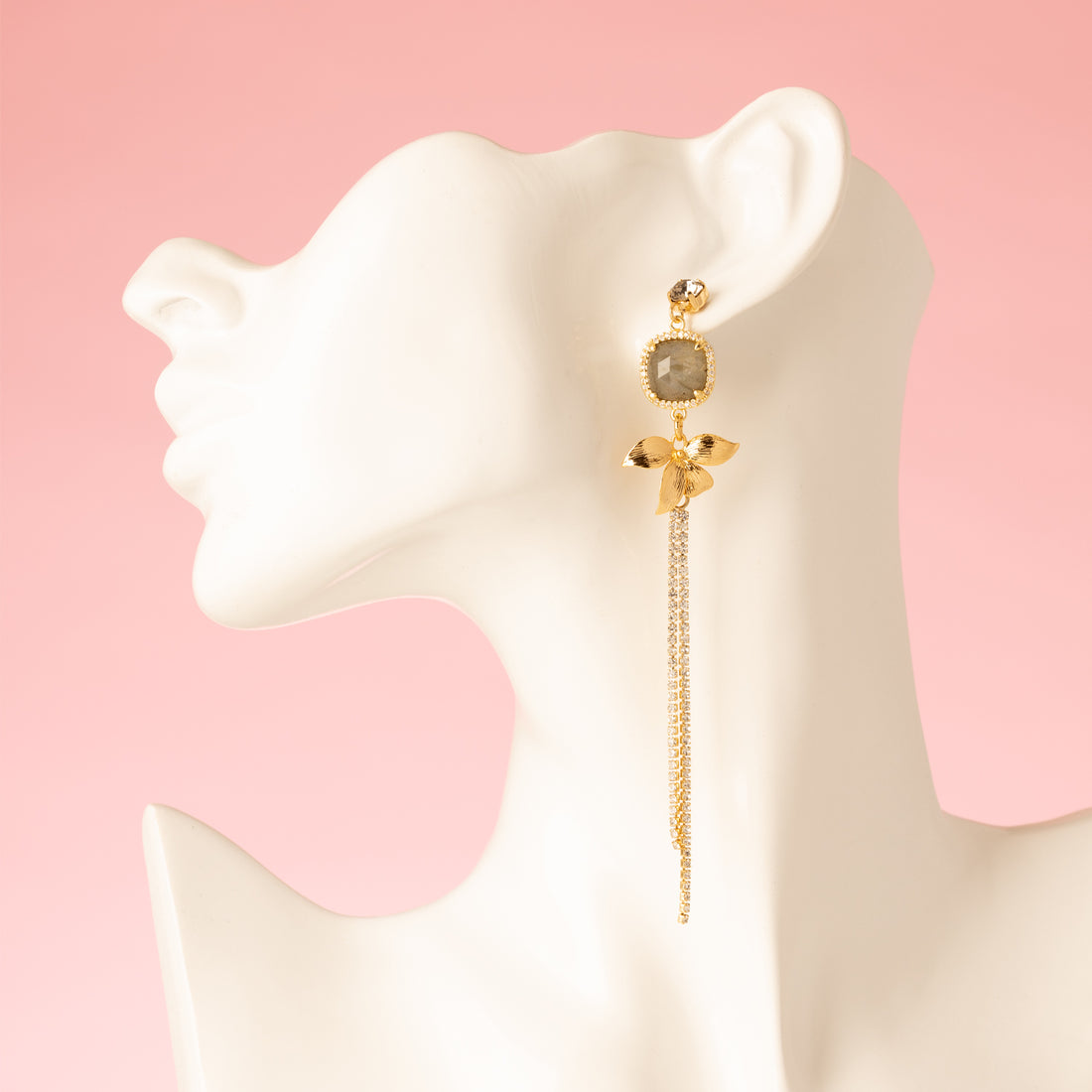 Voeg een subtiel en verfijnd accent toe met de Aurora Bloom asymmetrische oorbellen. De oorbellen hebben een fonkelende Swarovski oorsteker, een gouden bloem, sprankelende zirkonia cirkels en een prachtige spectrolite edelsteen die een zacht kleurenspel laat zien bij iedere beweging. Het asymmetrische ontwerp geeft een speels, elegant karakter en maakt deze oorbellen perfect voor een etentje, een speciale gelegenheid of om je dagelijkse look een verfijnde touch te geven.