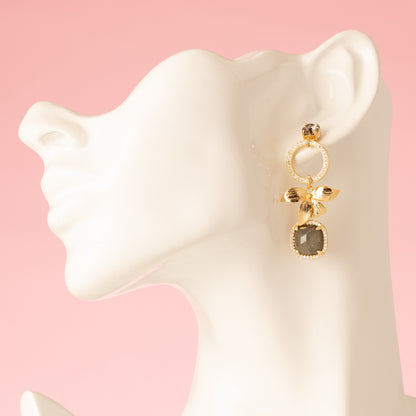 Voeg een subtiel en verfijnd accent toe met de Aurora Bloom asymmetrische oorbellen. De oorbellen hebben een fonkelende Swarovski oorsteker, een gouden bloem, sprankelende zirkonia cirkels en een prachtige spectrolite edelsteen die een zacht kleurenspel laat zien bij iedere beweging. Het asymmetrische ontwerp geeft een speels, elegant karakter en maakt deze oorbellen perfect voor een etentje, een speciale gelegenheid of om je dagelijkse look een verfijnde touch te geven.