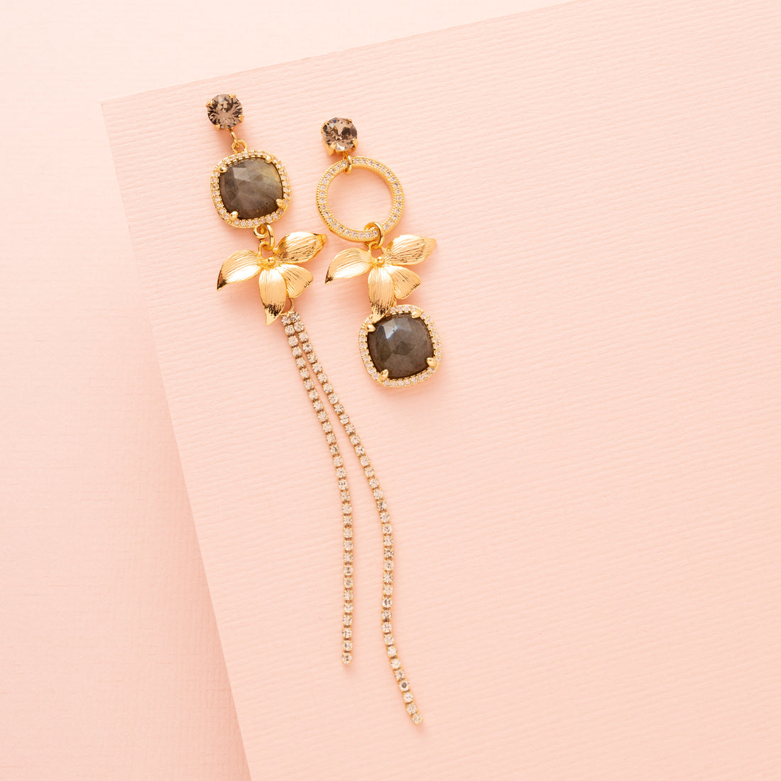 Voeg een subtiel en verfijnd accent toe met de Aurora Bloom asymmetrische oorbellen. De oorbellen hebben een fonkelende Swarovski oorsteker, een gouden bloem, sprankelende zirkonia cirkels en een prachtige spectrolite edelsteen die een zacht kleurenspel laat zien bij iedere beweging. Het asymmetrische ontwerp geeft een speels, elegant karakter en maakt deze oorbellen perfect voor een etentje, een speciale gelegenheid of om je dagelijkse look een verfijnde touch te geven.