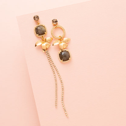 Voeg een subtiel en verfijnd accent toe met de Aurora Bloom asymmetrische oorbellen. De oorbellen hebben een fonkelende Swarovski oorsteker, een gouden bloem, sprankelende zirkonia cirkels en een prachtige spectrolite edelsteen die een zacht kleurenspel laat zien bij iedere beweging. Het asymmetrische ontwerp geeft een speels, elegant karakter en maakt deze oorbellen perfect voor een etentje, een speciale gelegenheid of om je dagelijkse look een verfijnde touch te geven.