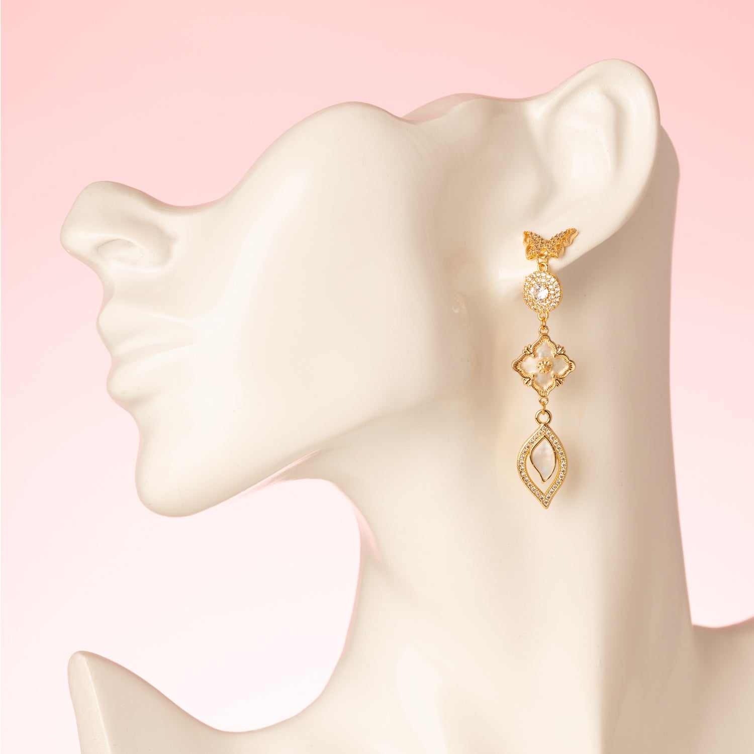 Deze prachtige asymmetrische oorbellen zijn een waar statement. De stekers zijn in de vorm van een elegante vlinder, die een verfijnde en delicate uitstraling geeft. De oorbellen zijn verder versierd met schitterende zirkonia en parelmoer stenen, wat zorgt voor een luxe en sprankelend effect. Een subtiele fringe van zirkonia steentjes voegt een speels en sierlijk element toe aan het geheel.