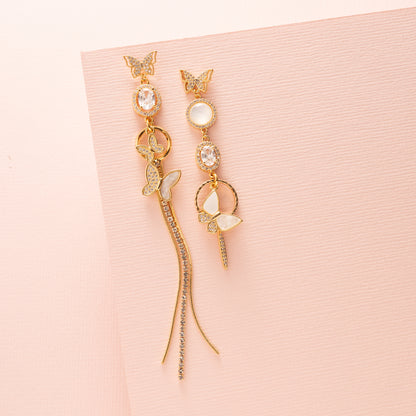 Laat je betoveren door Delicate Wings – een paar asymmetrische statement oorbellen waarin elegantie en lef samenkomen. Beide oorstekers zijn vormgegeven als verfijnde vlinders, rijk bezet met glinsterende zirkonia’s en parelmoer accenten. Aan de ene oorbel zweven twee vlinders sierlijk onder elkaar, aan de andere één vlinder – een subtiel spel van balans en asymmetrie.