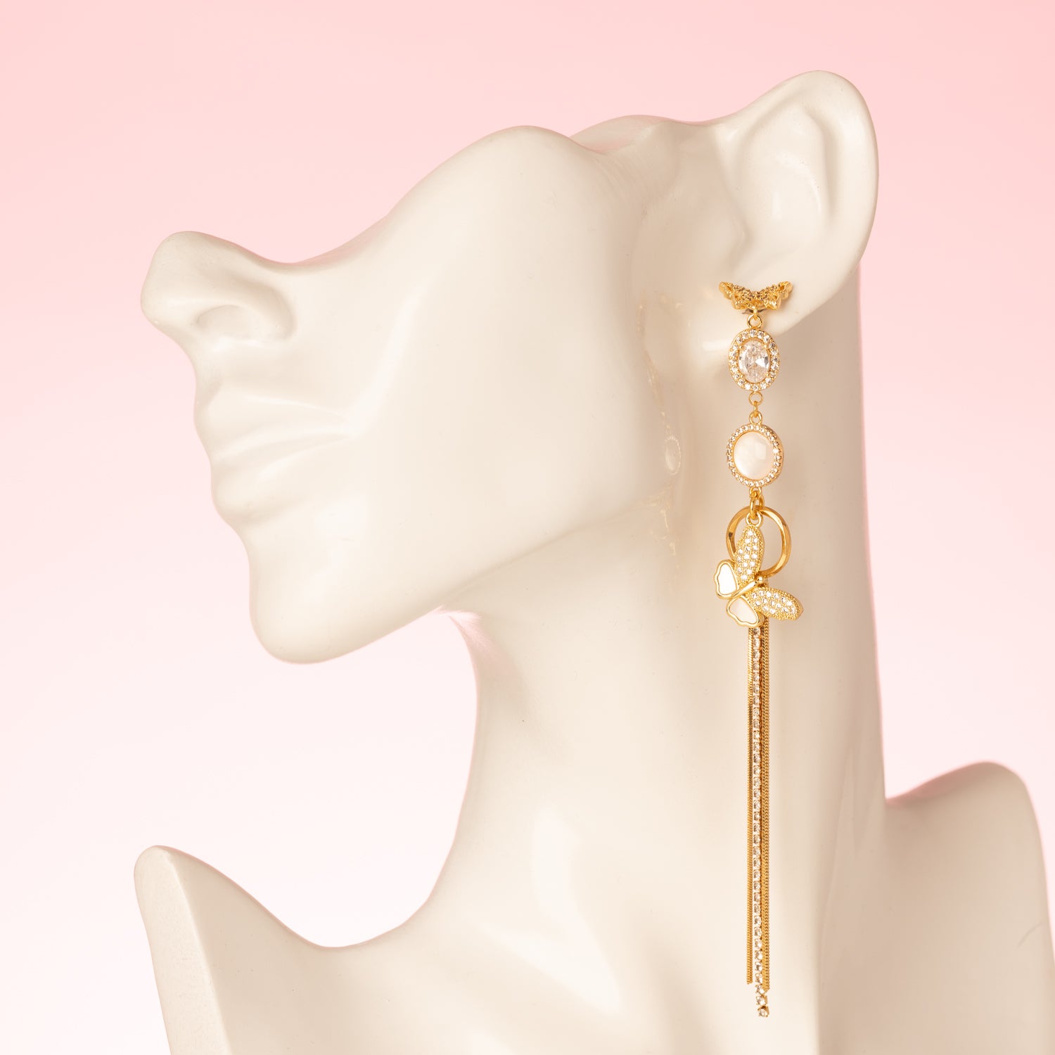 Deze prachtige asymmetrische oorbellen zijn een waar statement. De stekers zijn in de vorm van een elegante vlinder, die een verfijnde en delicate uitstraling geeft. De oorbellen zijn verder versierd met schitterende zirkonia en parelmoer stenen, wat zorgt voor een luxe en sprankelend effect. Een subtiele fringe van zirkonia steentjes voegt een speels en sierlijk element toe aan het geheel.